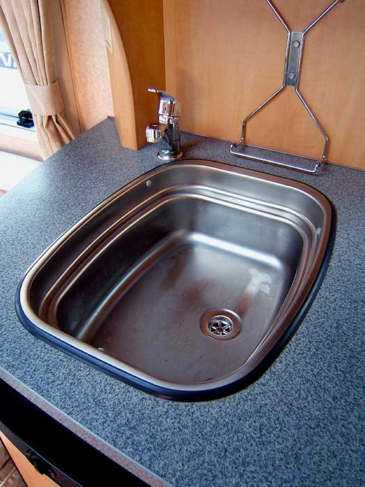 The stainless steel sink ( with single mixer tap ) inset into the worktop.